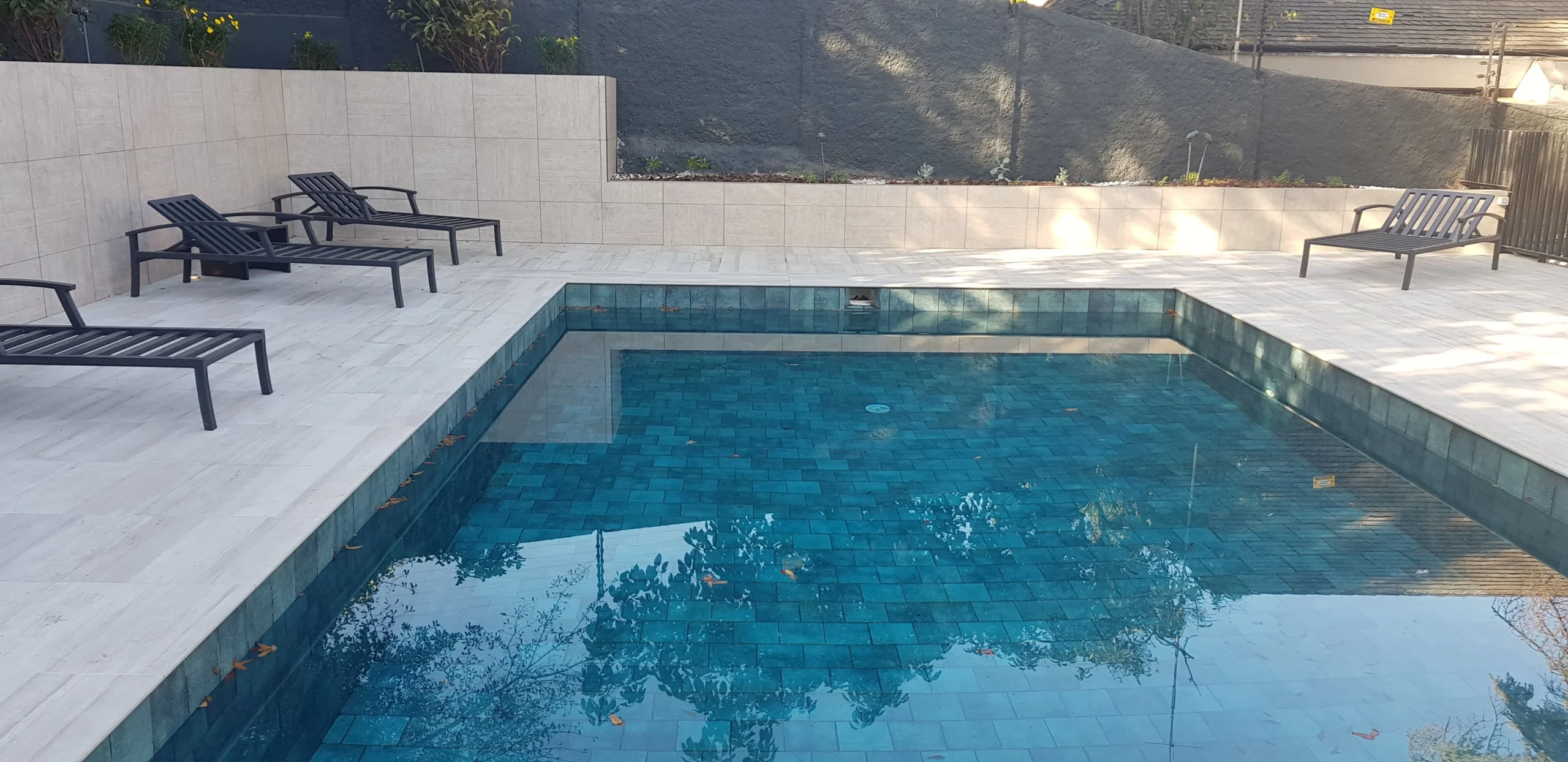 Piscina de cliente con mosaicos Pedra Bela y tonos de expresión natural
